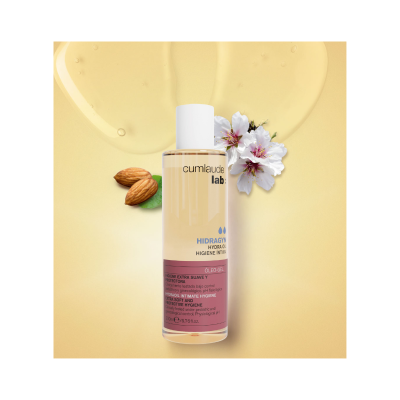 Frasco de óleo-gel para higiene íntima cumlaude lab: HIDRAGYN sobre fundo amarelo com amêndoas e flores