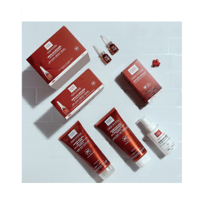 Produtos MARTIDERM HAIR SYSTEM em embalagens vermelhas sobre azulejos brancos