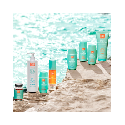 Produtos solares Marti Derm em pedras junto a água azul claro