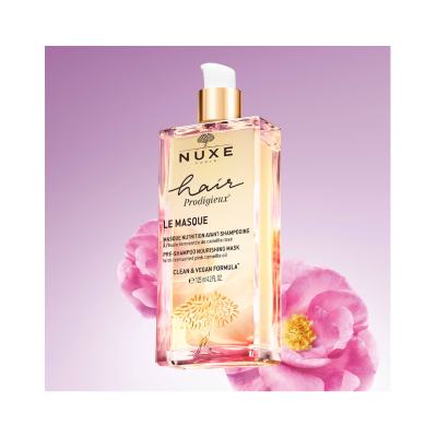 Frasco da máscara capilar NUXE hair Prodigieux LE MASQUE com fundo lilás e flores rosa
