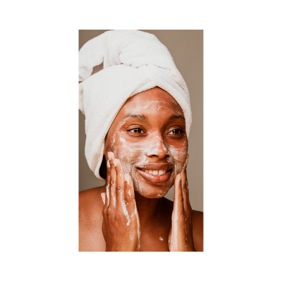 Mulher aplicando espuma facial com toalha na cabeça