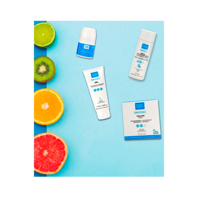 Produtos cosméticos MARTIDERM DRIOSEC com frutas cortadas sobre fundo azul