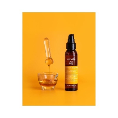 Frasco de produto capilar APIVITA Keratin Repair com conta-gotas e líquido âmbar em recipiente de vidro
