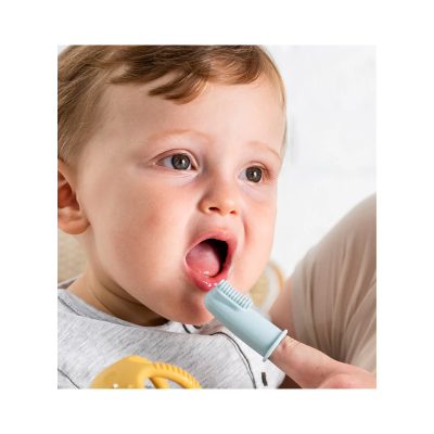 Criança a ter os dentes limpos com escova de silicone azul clara