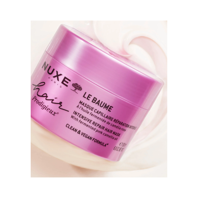 Frasco rosa metálico de creme para cabelo NUXE Paris com texto em francês e inglês