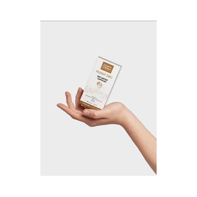 Mão feminina a segurar uma caixa de cápsulas MartiDerm Pigment Zero DSP-Antiox