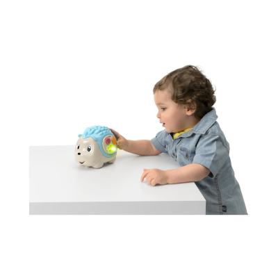 Criança a brincar com brinquedo porco-espinho colorido em mesa branca