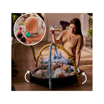 Tapete de atividades para bebé com brinquedos pendurados e mulher a brincar com o bebé no chão de madeira