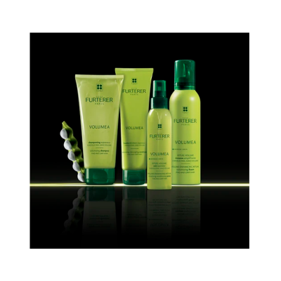 Produtos capilares Furterer Volumea em embalagens verdes sobre superfície preta reflexiva