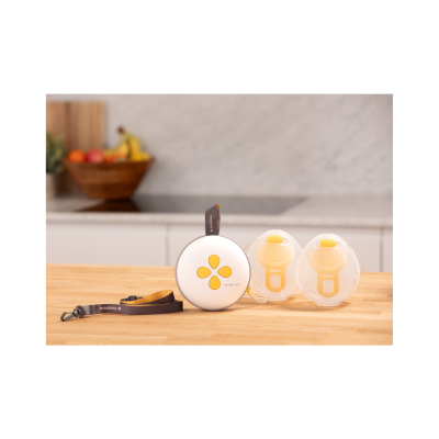 Conjunto Medela Swing Maxi com estojo branco e amarelo e duas conchas transparentes em bancada de cozinha.