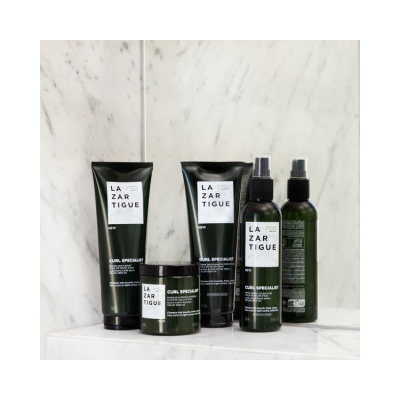 Produtos de cuidado capilar LAZARTIGUE embalagem verde e branca em mármore branco