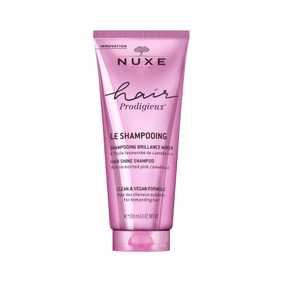 Frasco rosa metálico de champô Nuxe Hair Prodigieux com texto em preto e branco