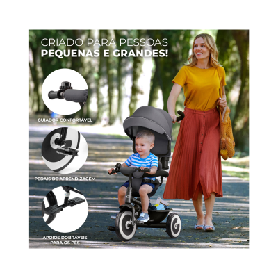 Triciclo infantil preto com capota cinzenta usado por criança e mulher empurrando no parque