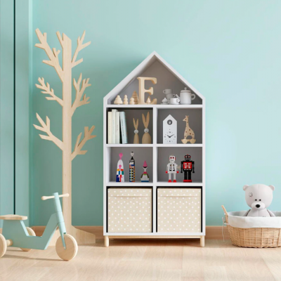 Móvel prateleira branca em forma de casa com objetos decorativos e triciclo azul ao lado