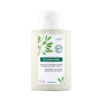 Frasco de champô Klorane com rótulo verde e branco e ilustração de folhas