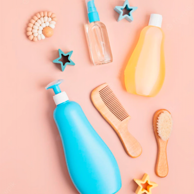 Produtos de cuidados pessoais em fundo cor de pêssego com frascos, pente, escova, estrelas decorativas e colar de contas.