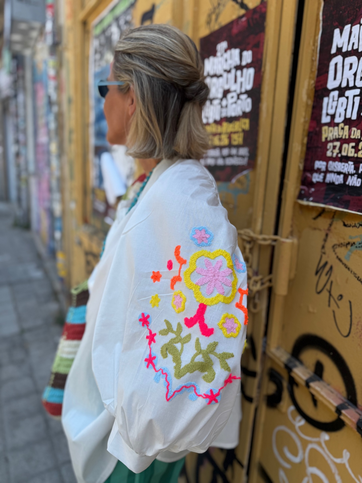 Blusa branca com bordados coloridos florais na manga bufante.