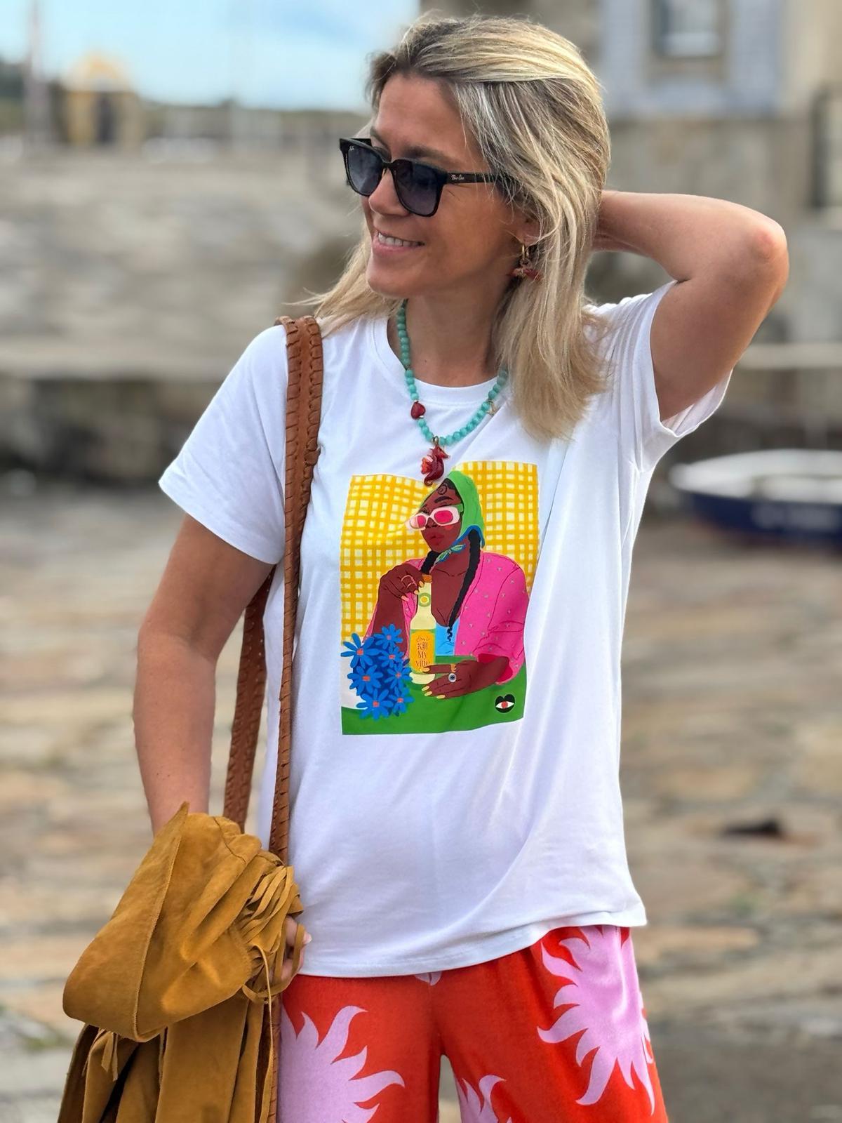 Mulher com camisola branca estampada e calças vermelhas com padrão rosa