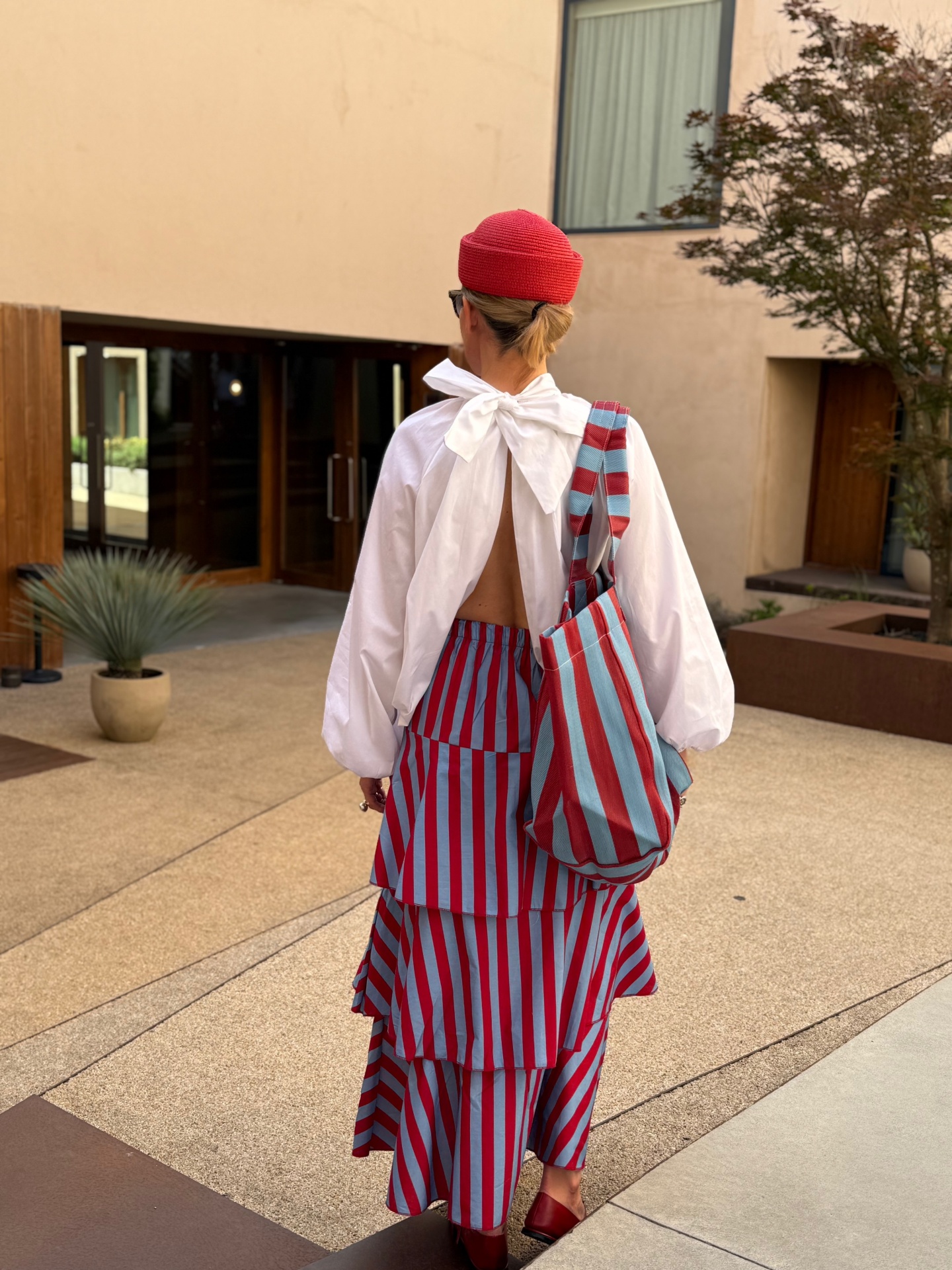 Mulher com chapéu vermelho e roupa com riscas vermelhas e azuis