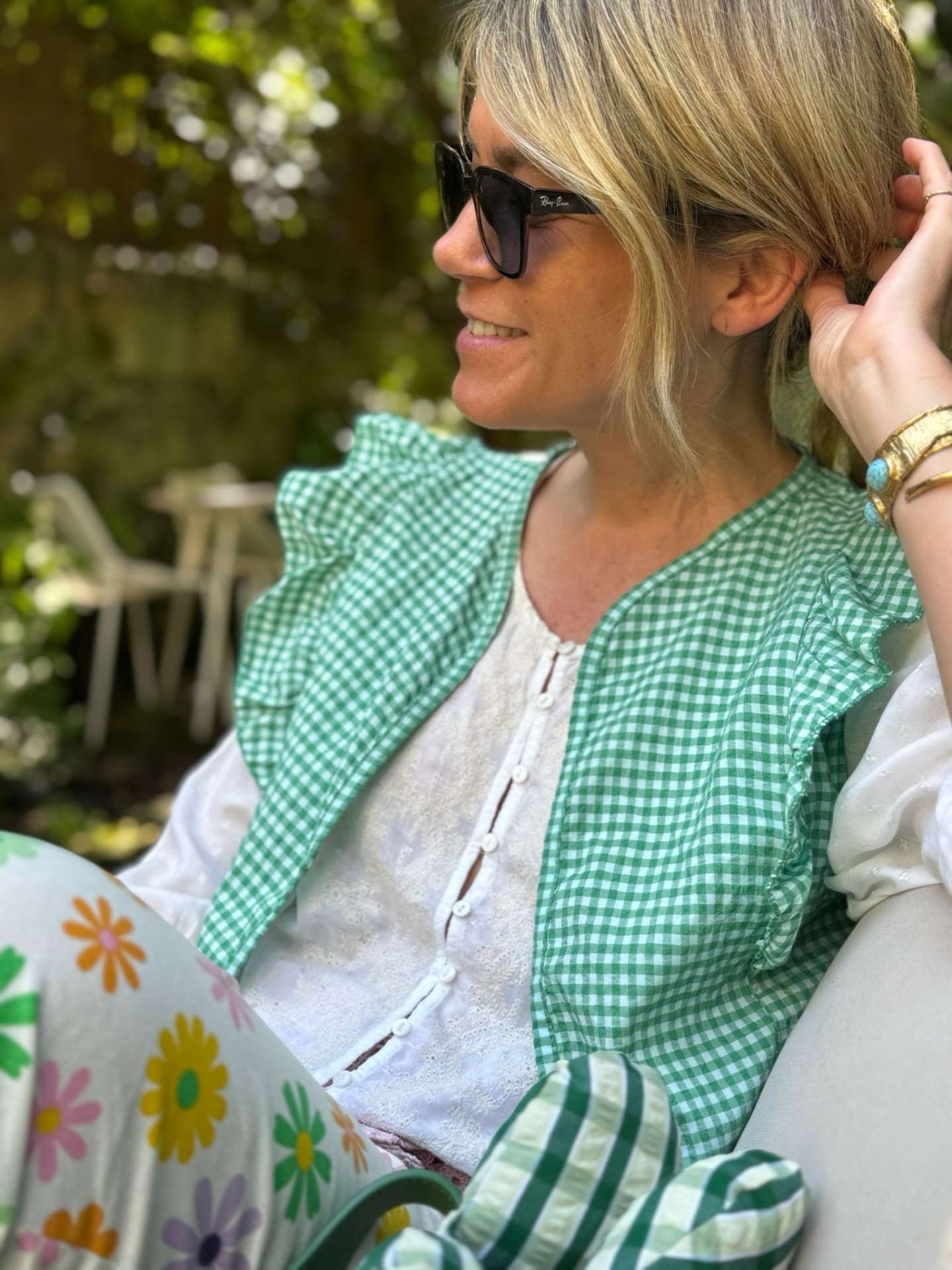 Mulher com óculos de sol e roupa colorida em ambiente exterior