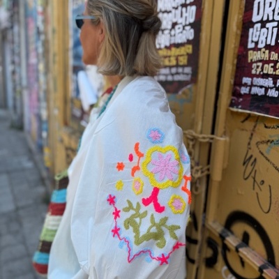 Blusa branca com bordados coloridos florais na manga bufante.