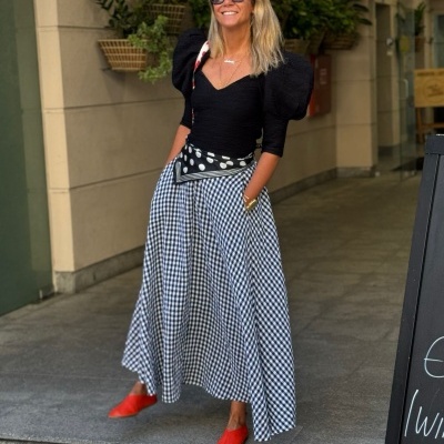 Mulher com vestido xadrez preto e branco e sapatos vermelhos