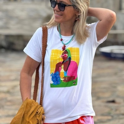 Mulher com camisola branca estampada e calças vermelhas com padrão rosa