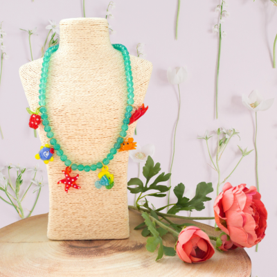 Colar colorido com pingentes em busto de tecido e flores decorativas
