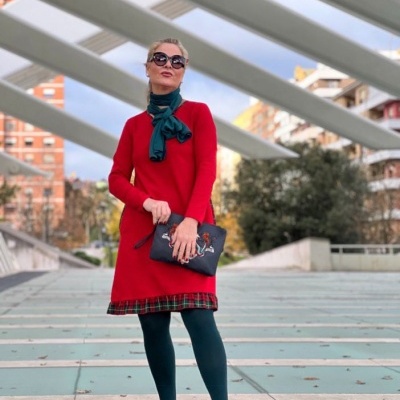 Mulher com vestido vermelho e acessório azul em ambiente urbano moderno