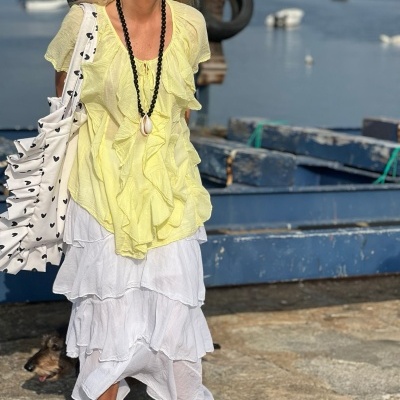 Mulher com roupa leve e colorida junto a cais