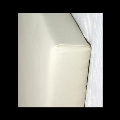 Cabeceira de cama estofada branca junto a parede com papel riscado