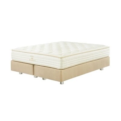 Colchão branco matelassê em base de cama bege com pés metálicos