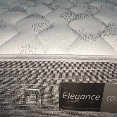 Colchão acolchoado branco e cinza com etiqueta Elegance conforto