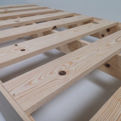 Estrutura de cama em madeira clara com ripas horizontais