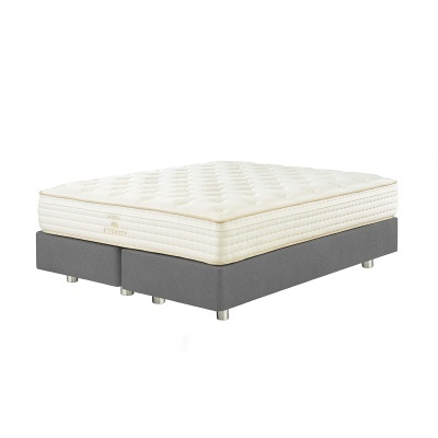 Colchão branco almofadado sobre estrado cinza escuro com pernas metálicas