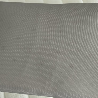 Mala cinzenta com padrão texturizado em relevo sobre superfície clara