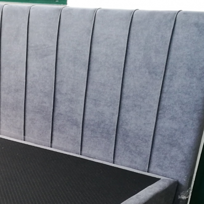 Cabeceira de cama estofada cinzenta com padrão acolchoado vertical