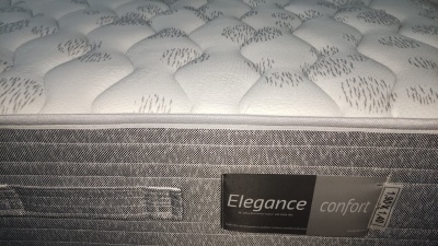 Colchão acolchoado branco e cinza com etiqueta Elegance conforto