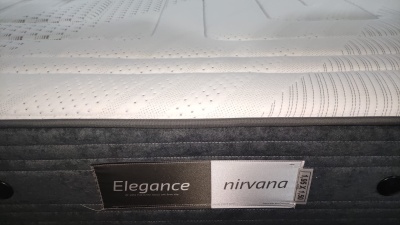 Colchão branco com padrão ondulado e etiqueta Elegance nirvana