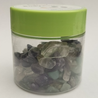 Pote transparente com tampa verde cheio de pedras coloridas