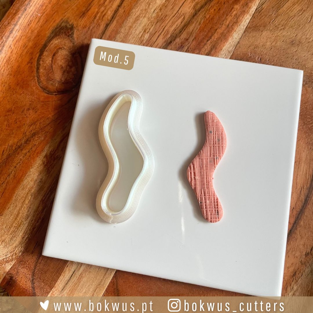 Cortadores formas orgânicas Molde cortador plástico branco e peça rosa texturizada em base branca