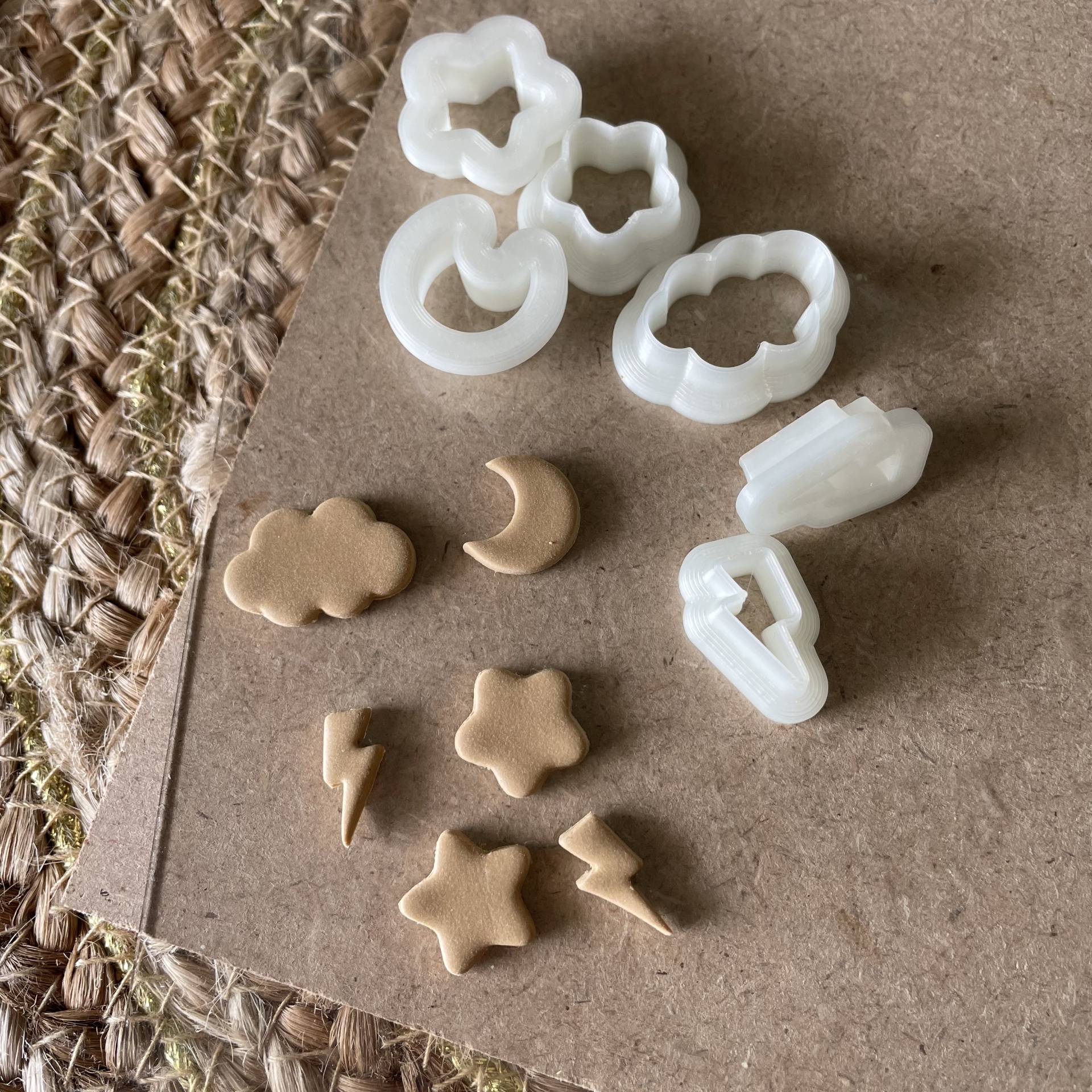 Conjunto de 6 cortadores - BC474 Cortadores de massa brancos e formas de massa bege sobre superfície de madeira.
