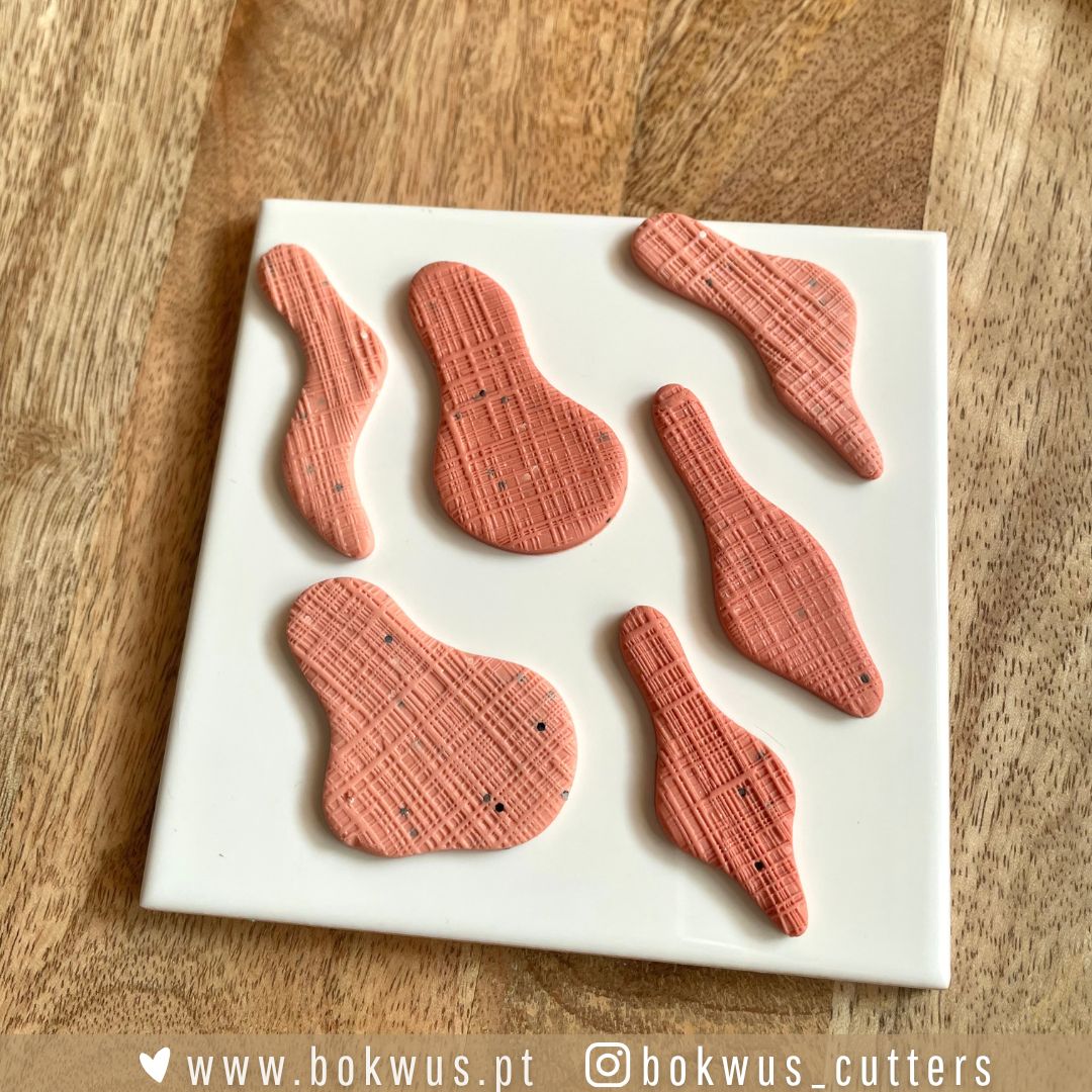 Cortadores formas orgânicas Conjunto de cortantes de modelagem rosa texturizados sobre base branca em madeira
