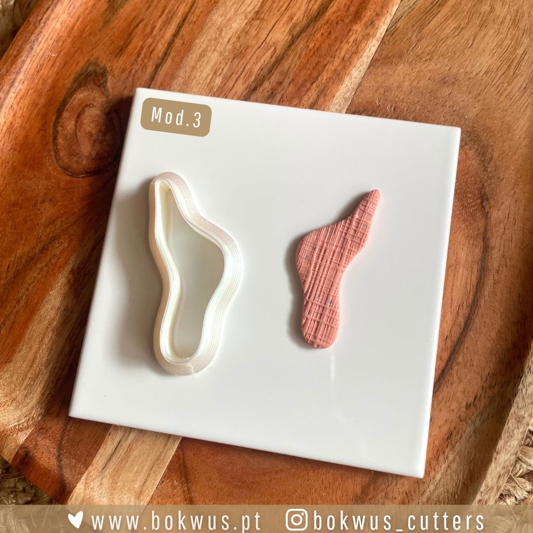 Cortadores formas orgânicas Cortador de massa branco e textura rosa sobre placa branca em fundo de madeira