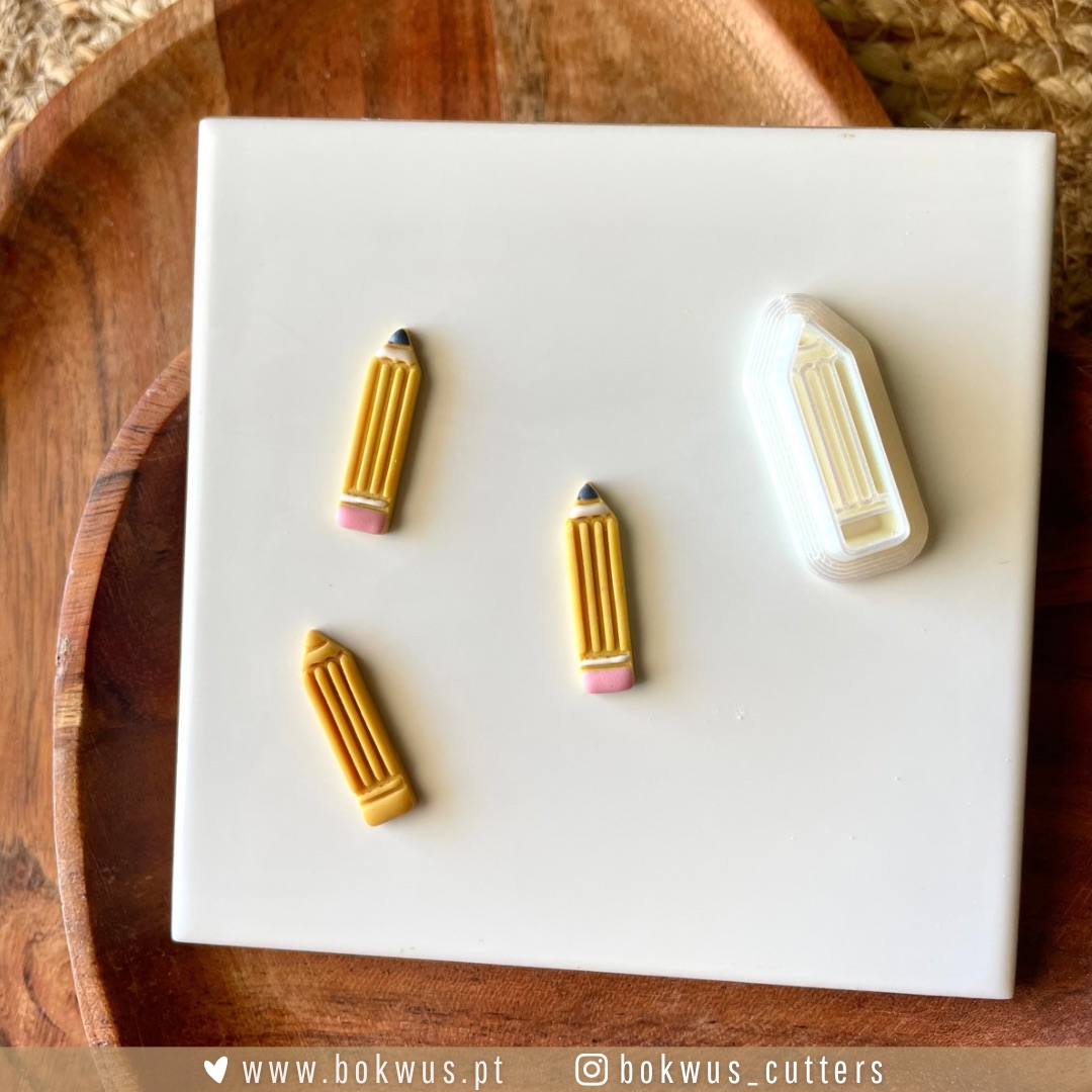 Cortador "De Volta à escola" | Lápis (2,5cm) | BC1592 Quatro objetos em forma de lápis sobre placa branca em fundo de madeira