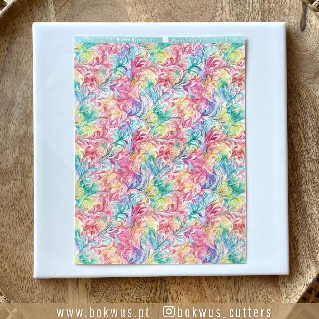 Papel tranfer - Aguarela I Quadrado branco com padrão colorido abstrato no centro sobre superfície de madeira clara