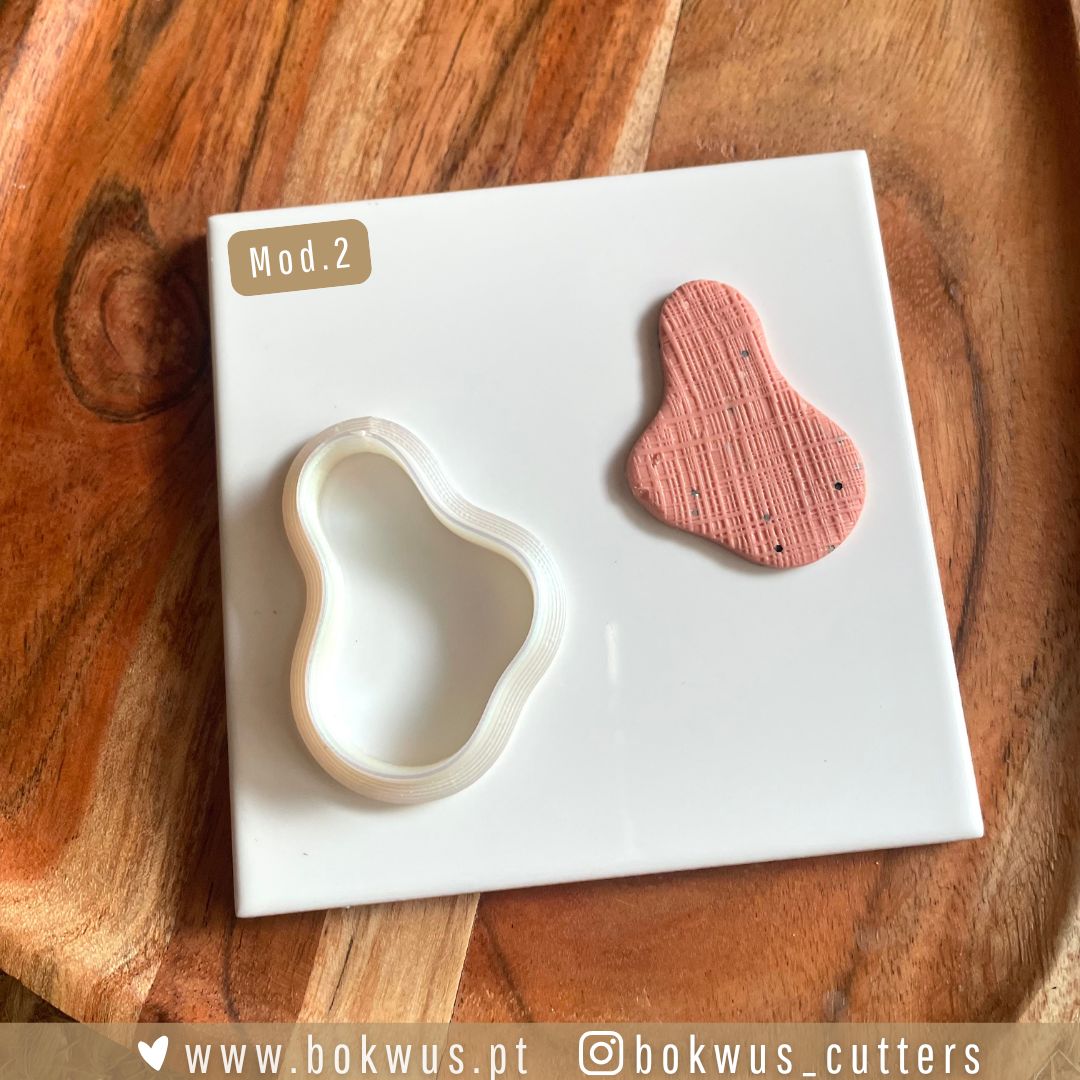 Cortadores formas orgânicas Formador de cortador em plástico branco e peça texturizada cor salmão sobre base branca e madeira