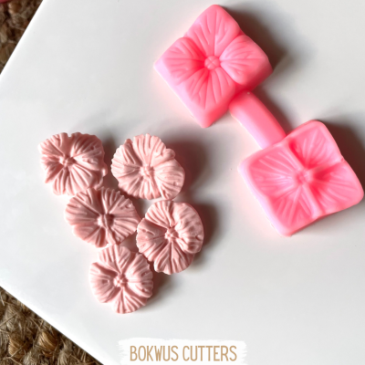 Cortadores de bolo rosa com forma de flor sobre superfície branca