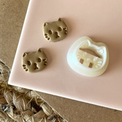 Peças em forma de cabeça de gato e molde branco sobre superfície rosa