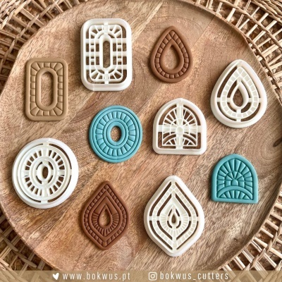 Conjunto de cortadores e moldes decorativos coloridos sobre prato de madeira